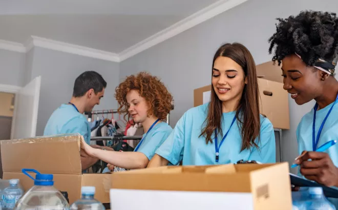 Quatre bénévoles alignés qui se tiennent les uns les autres